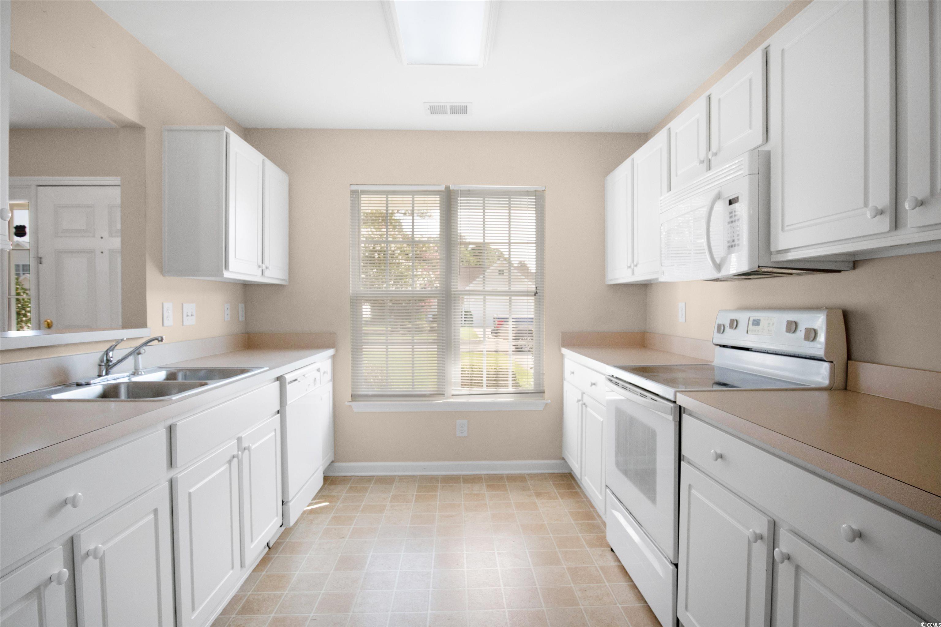 8005 Pleasant Point Lane Myrtle Beach, SC 29579 - Photo 8 of 27 Kitchen with sink, white appliances, light tile pa