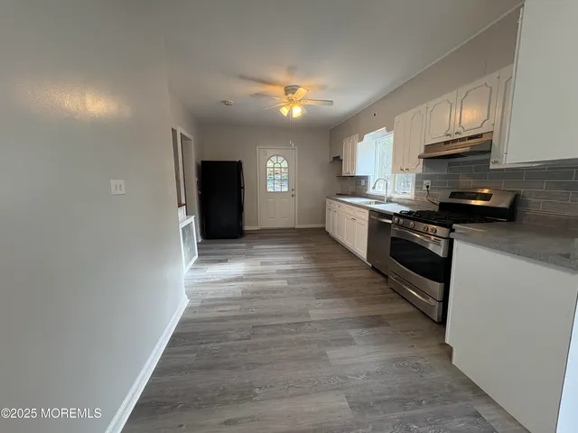 a kitchen with stainless steel appliances granite countertop a stove a sink and a refrigerator