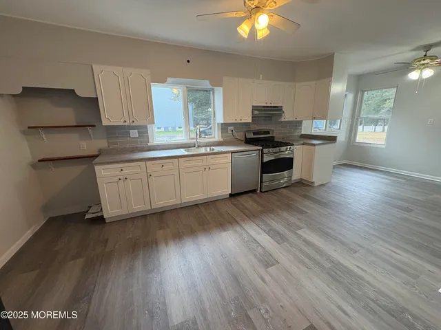 a kitchen with stainless steel appliances granite countertop a stove a sink and a refrigerator