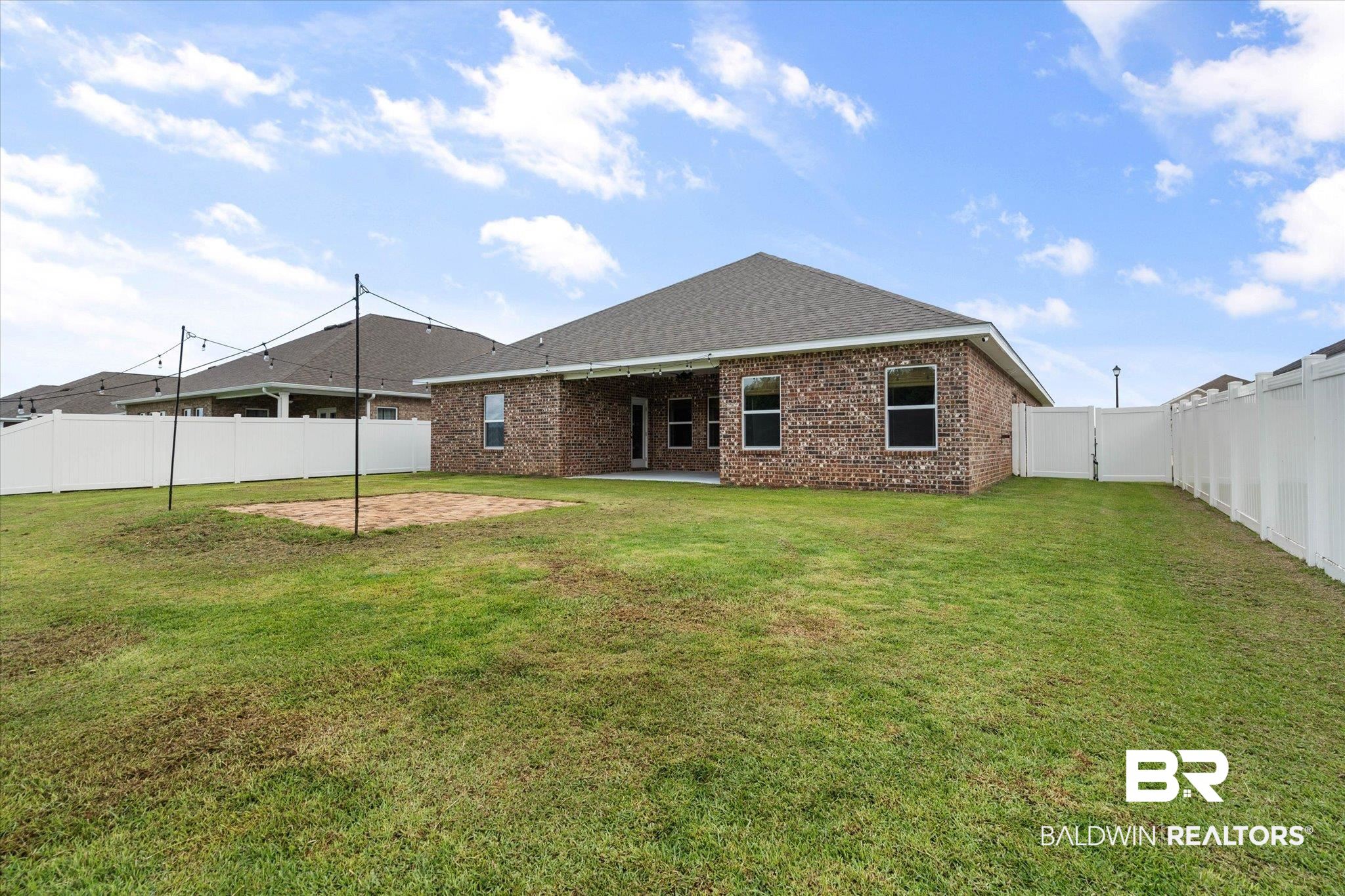 11229 Genuine Risk Circle Daphne, AL 36526 - Photo 27 of 46 Back of house featuring a fenced backyard, brick siding, a patio area, and roof with shingles
