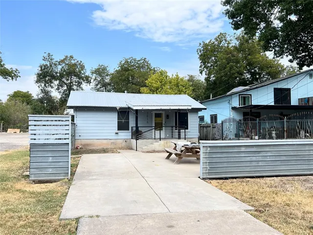 a view of a house with backyard and sitting area