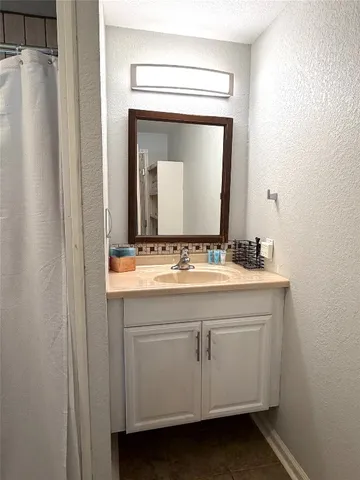 a bathroom with a sink vanity and a mirror