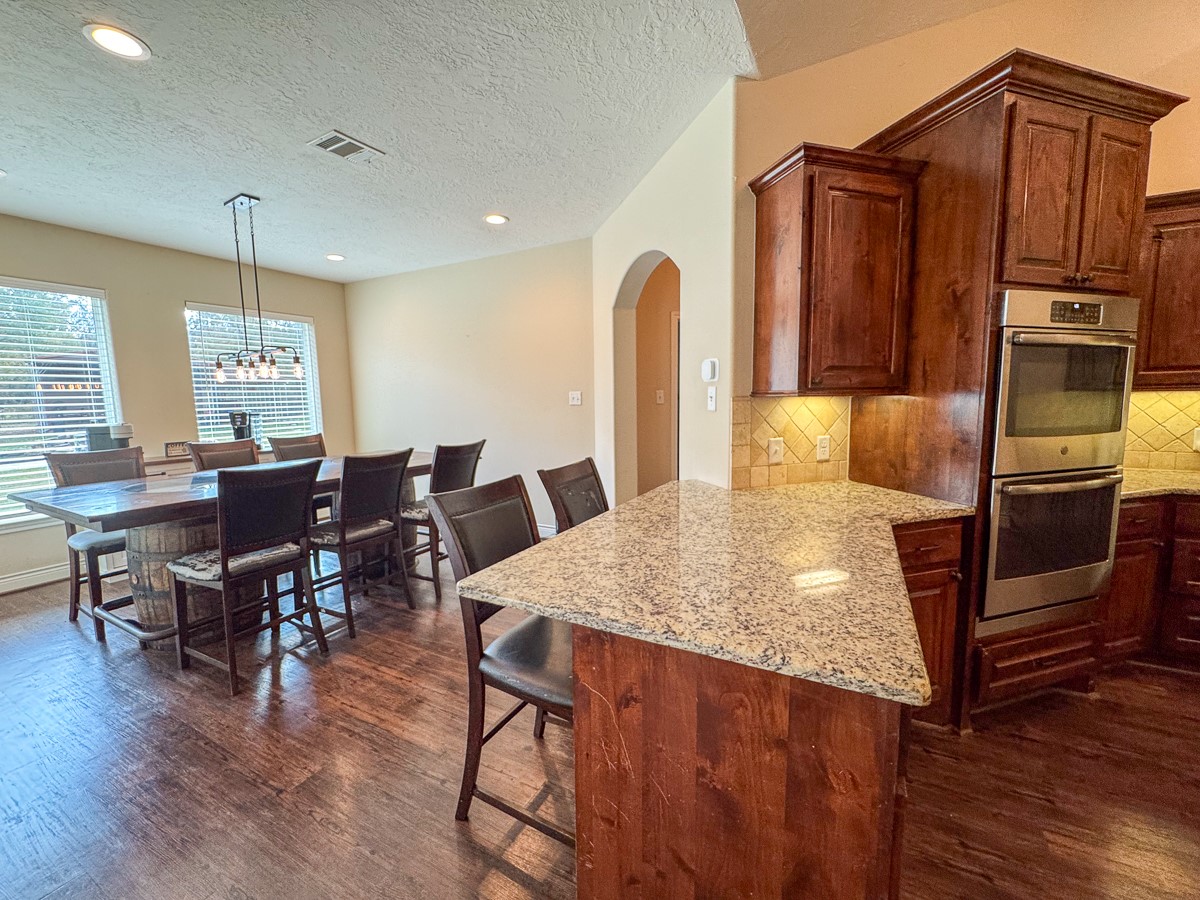 675 Somerset Trail Point Blank, TX 77364 - Photo 38 of 43 a kitchen with stainless steel appliances granite countertop a table chairs and a refrigerator