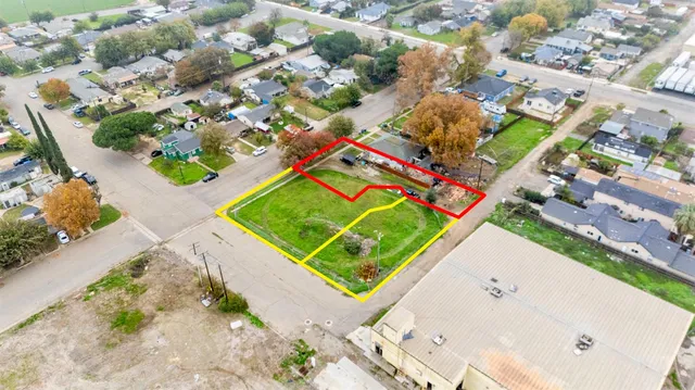an aerial view of a tennis ground and a white building with swimming pool