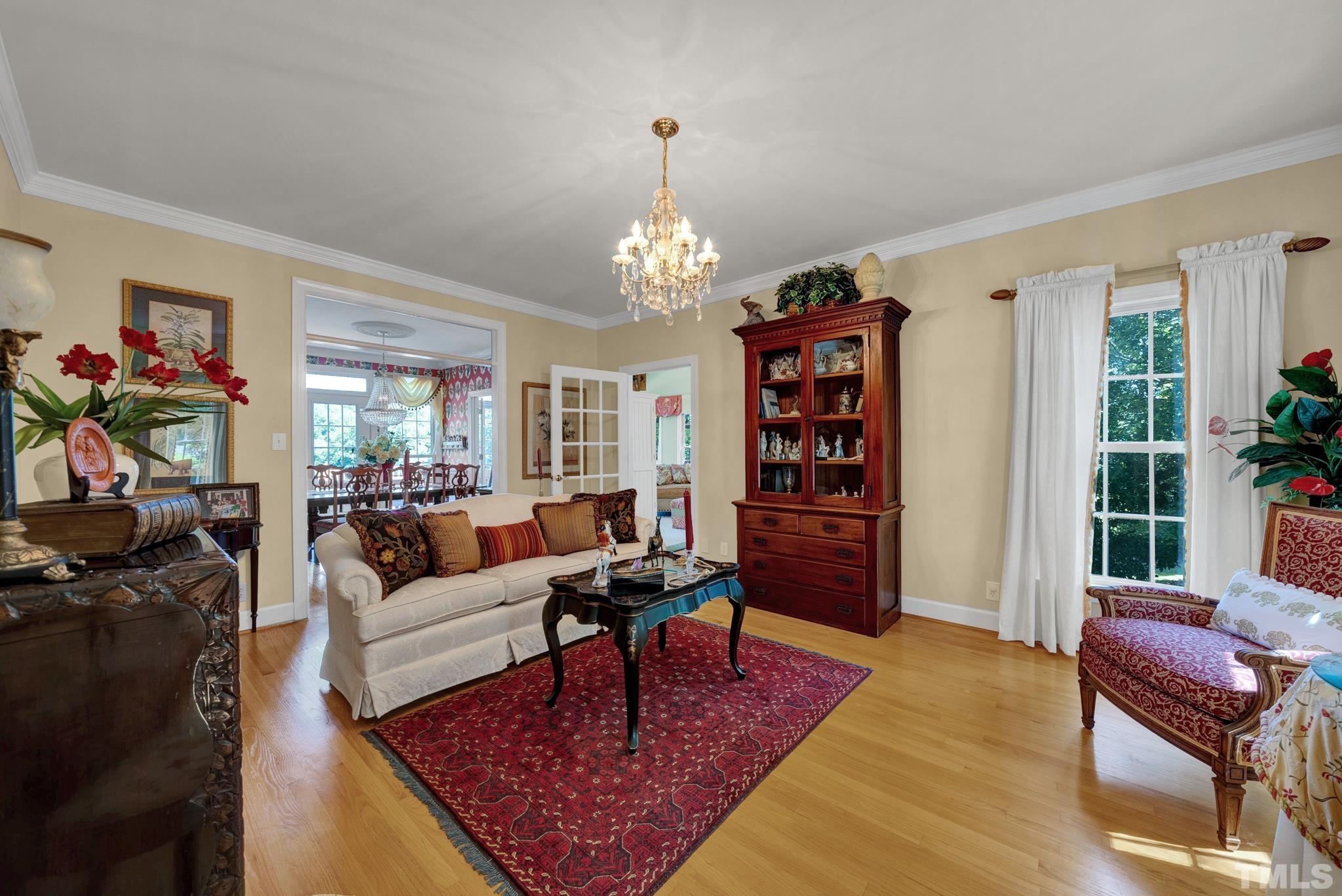 207 Holly Circle Clayton, NC 27527 - Photo 15 of 30 a living room with furniture a rug and a chandelier