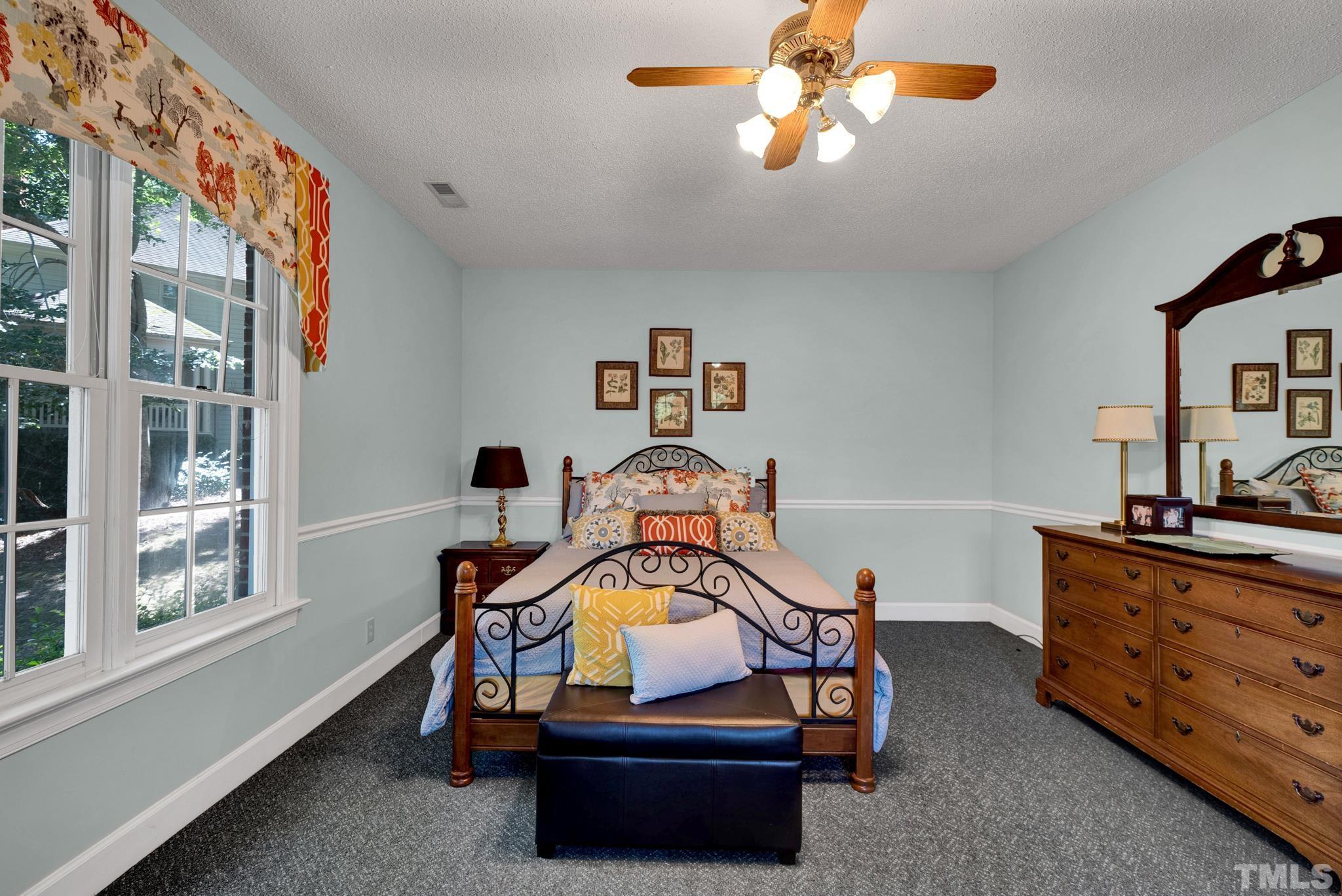 207 Holly Circle Clayton, NC 27527 - Photo 28 of 30 a bedroom with a bed and a chandelier