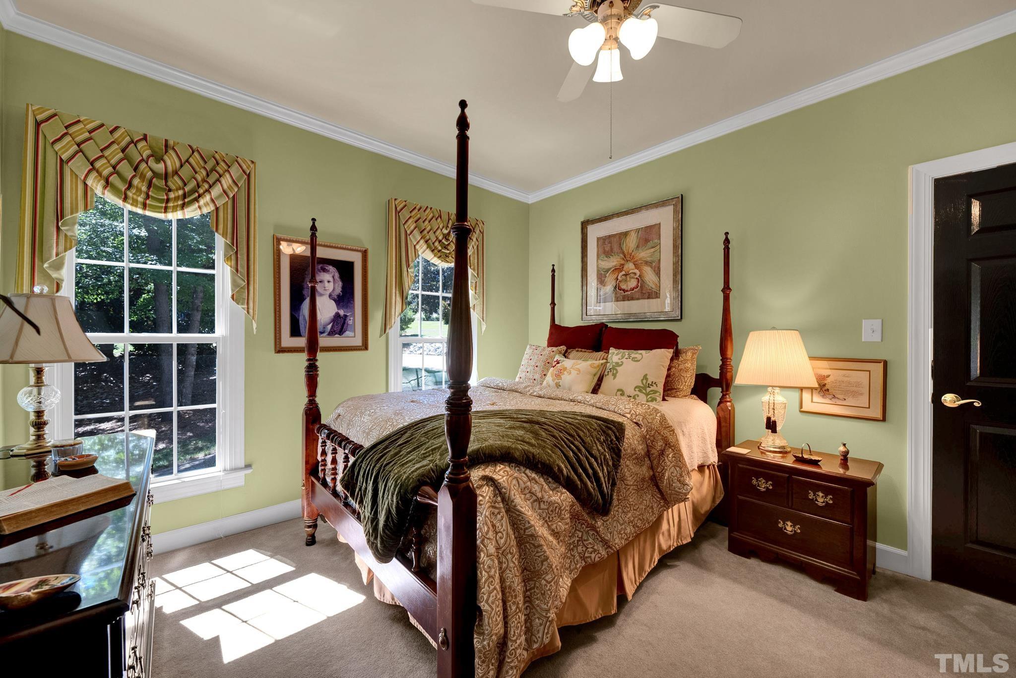 207 Holly Circle Clayton, NC 27527 - Photo 7 of 30 a bedroom with a bed and a chandelier