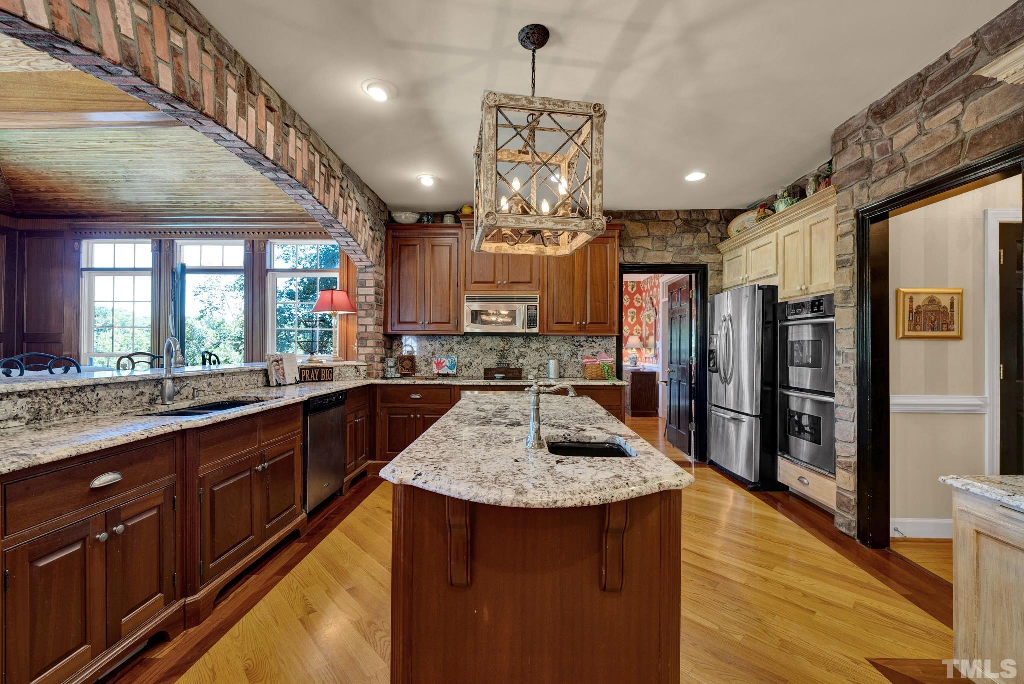 207 Holly Circle Clayton, NC 27527 - Photo 9 of 30 a kitchen with stainless steel appliances granite countertop a sink a stove and a wooden floors