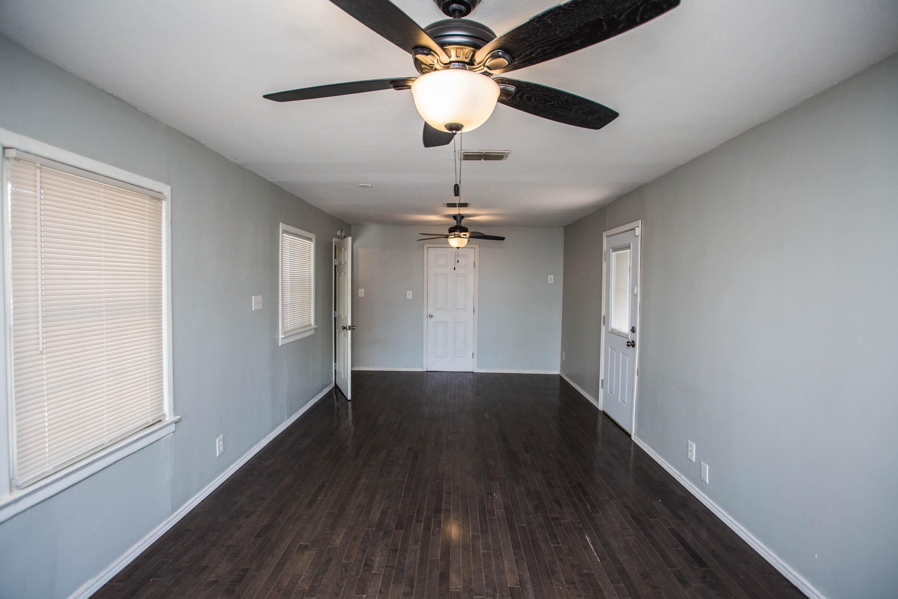 4213 40th Street Lubbock, TX 79413 - Photo 11 of 30 a view of an empty room with wooden floor and a window