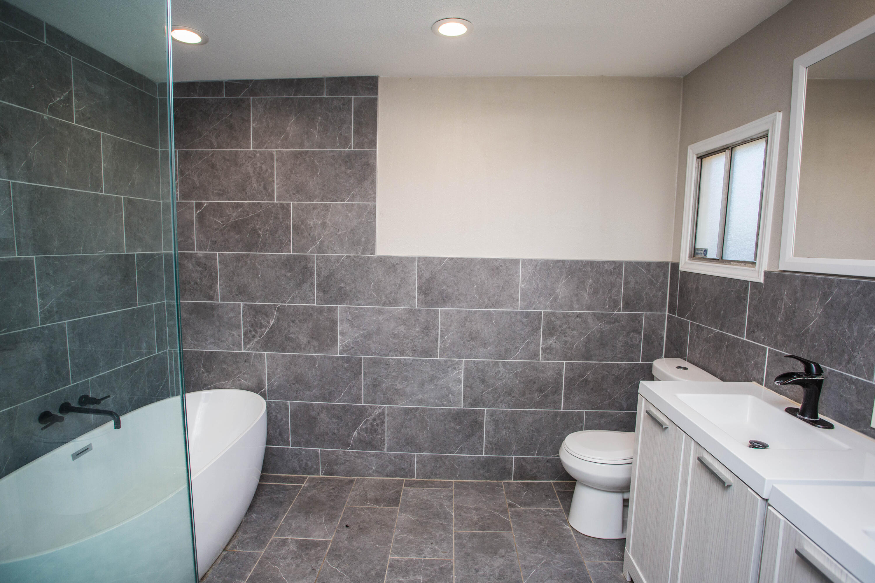 4213 40th Street Lubbock, TX 79413 - Photo 13 of 30 a bathroom with a toilet a sink and bathtub