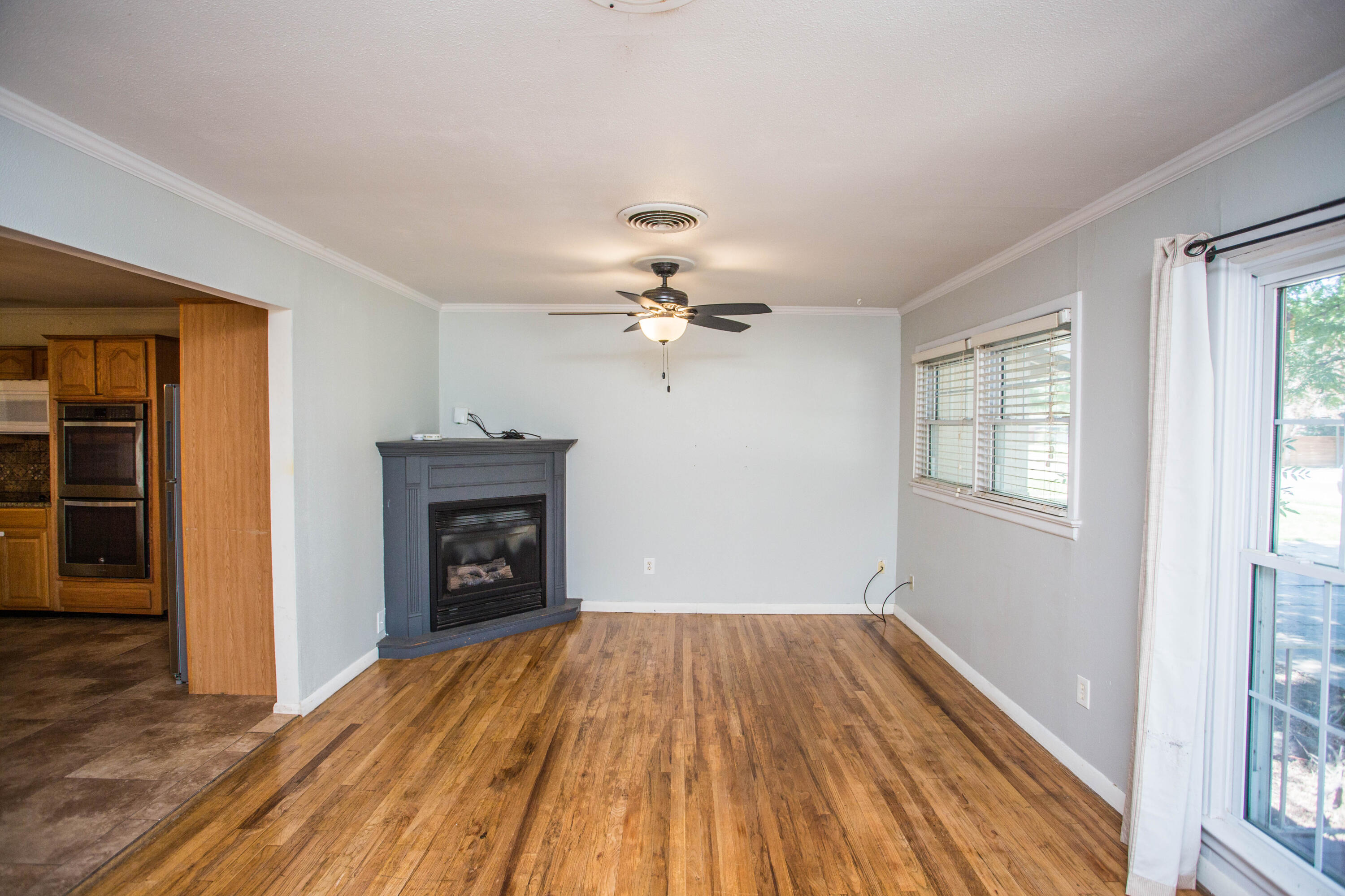 4213 40th Street Lubbock, TX 79413 - Photo 5 of 30 wooden floor in an empty room with a fireplace