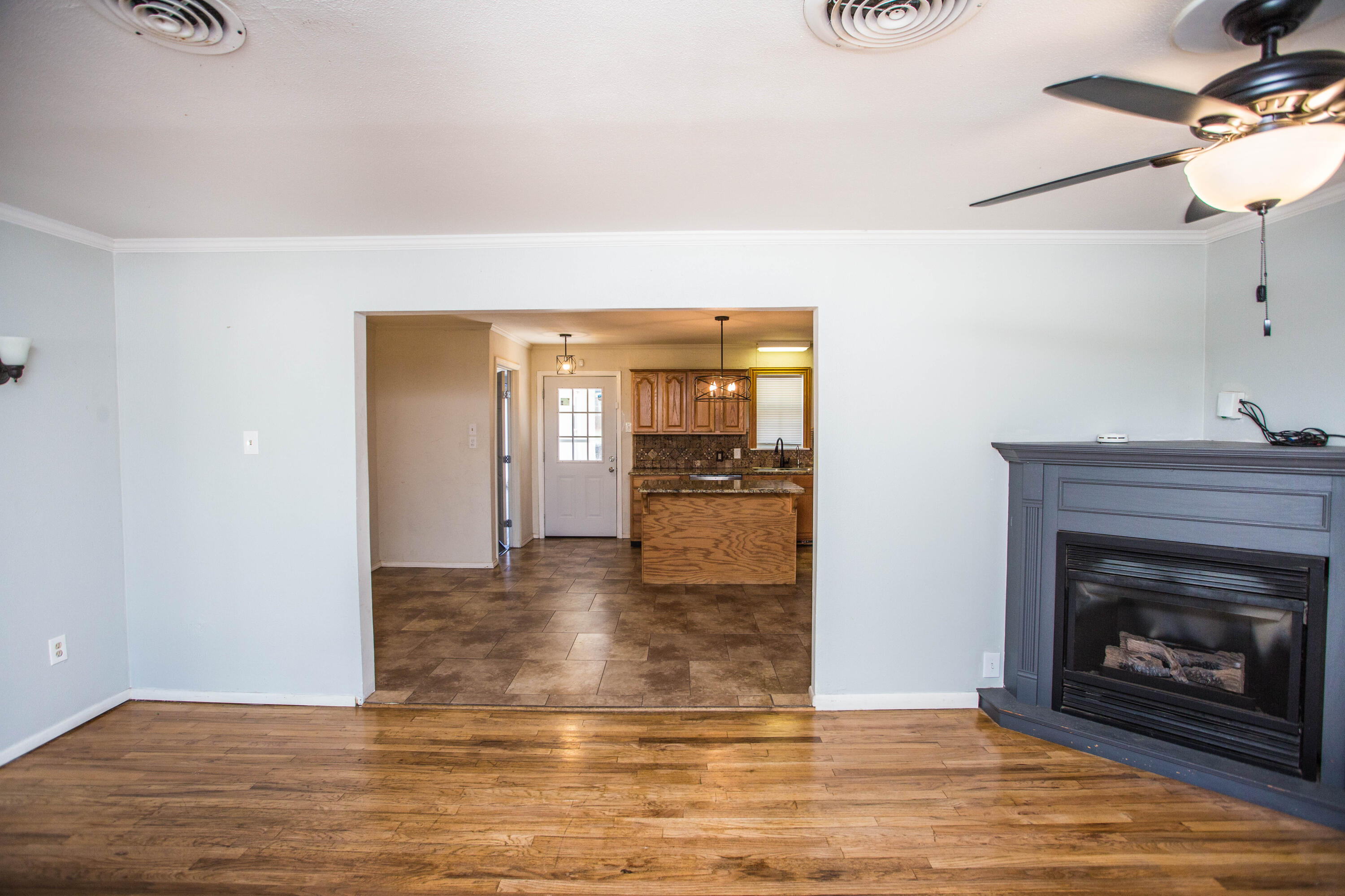 4213 40th Street Lubbock, TX 79413 - Photo 6 of 30 a view of a livingroom with wooden floor and a fireplace