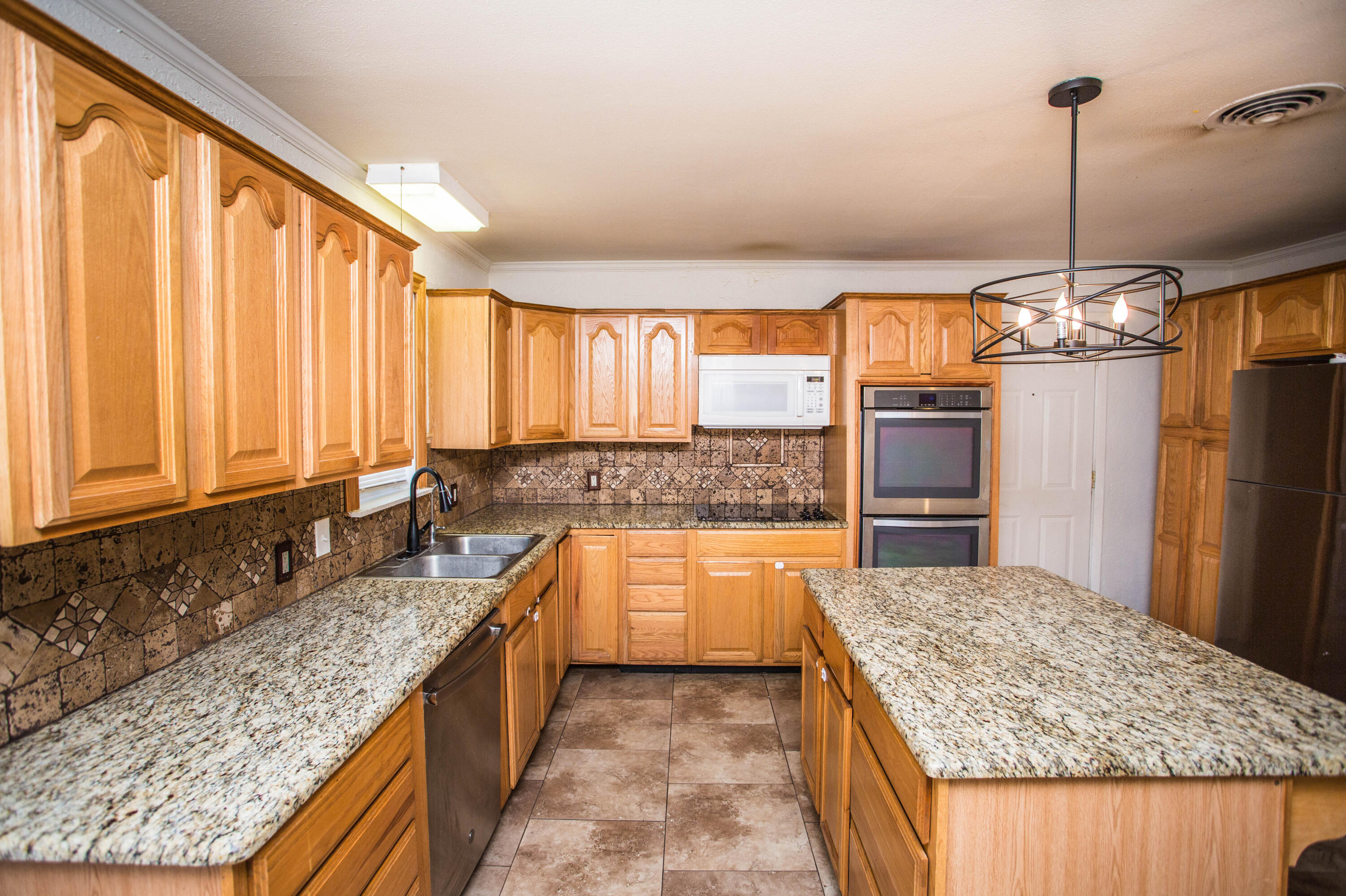4213 40th Street Lubbock, TX 79413 - Photo 8 of 30 a kitchen with stainless steel appliances granite countertop a sink counter space and a window
