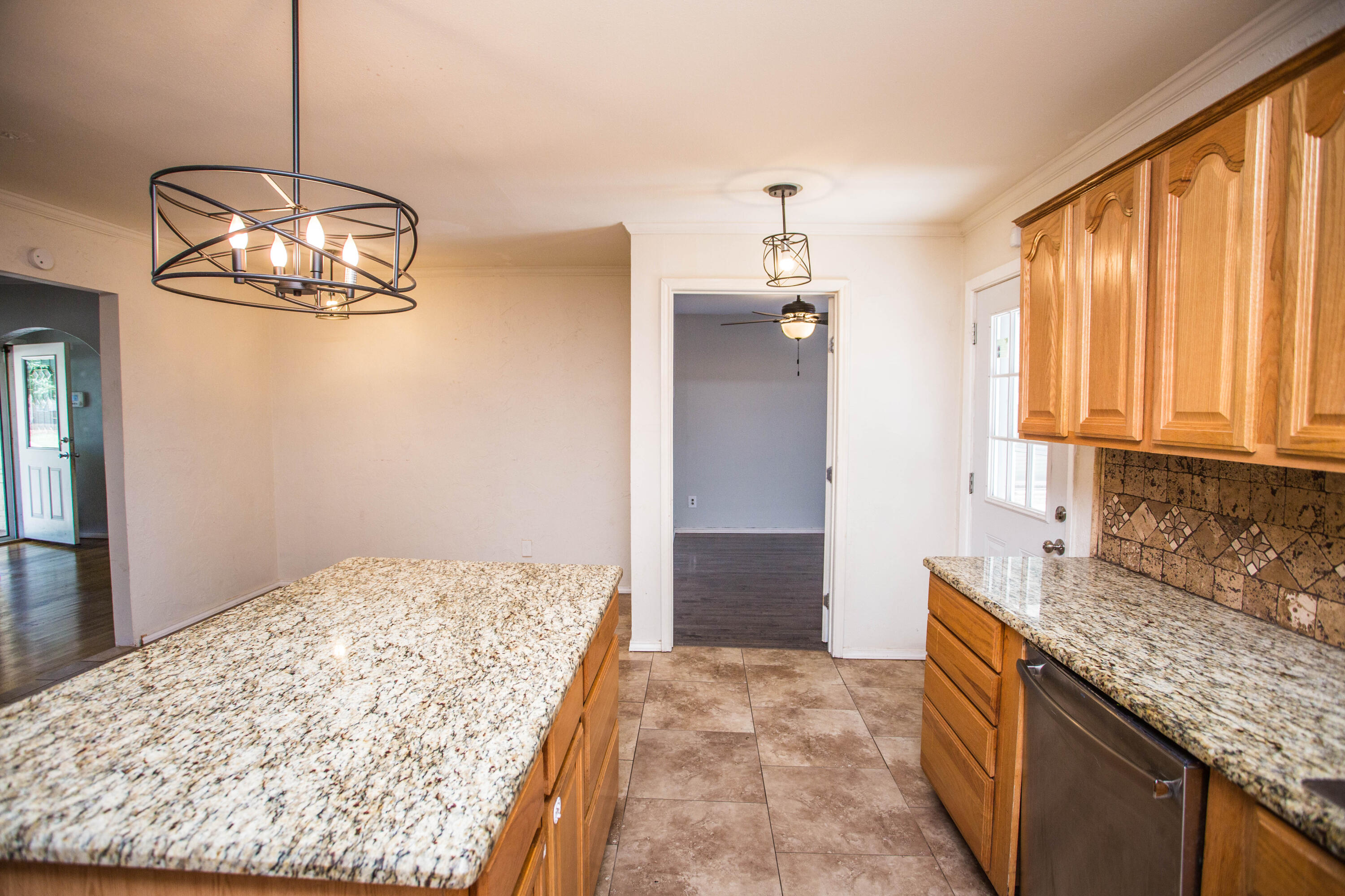 4213 40th Street Lubbock, TX 79413 - Photo 10 of 30 a kitchen with a chandelier and refrigerator