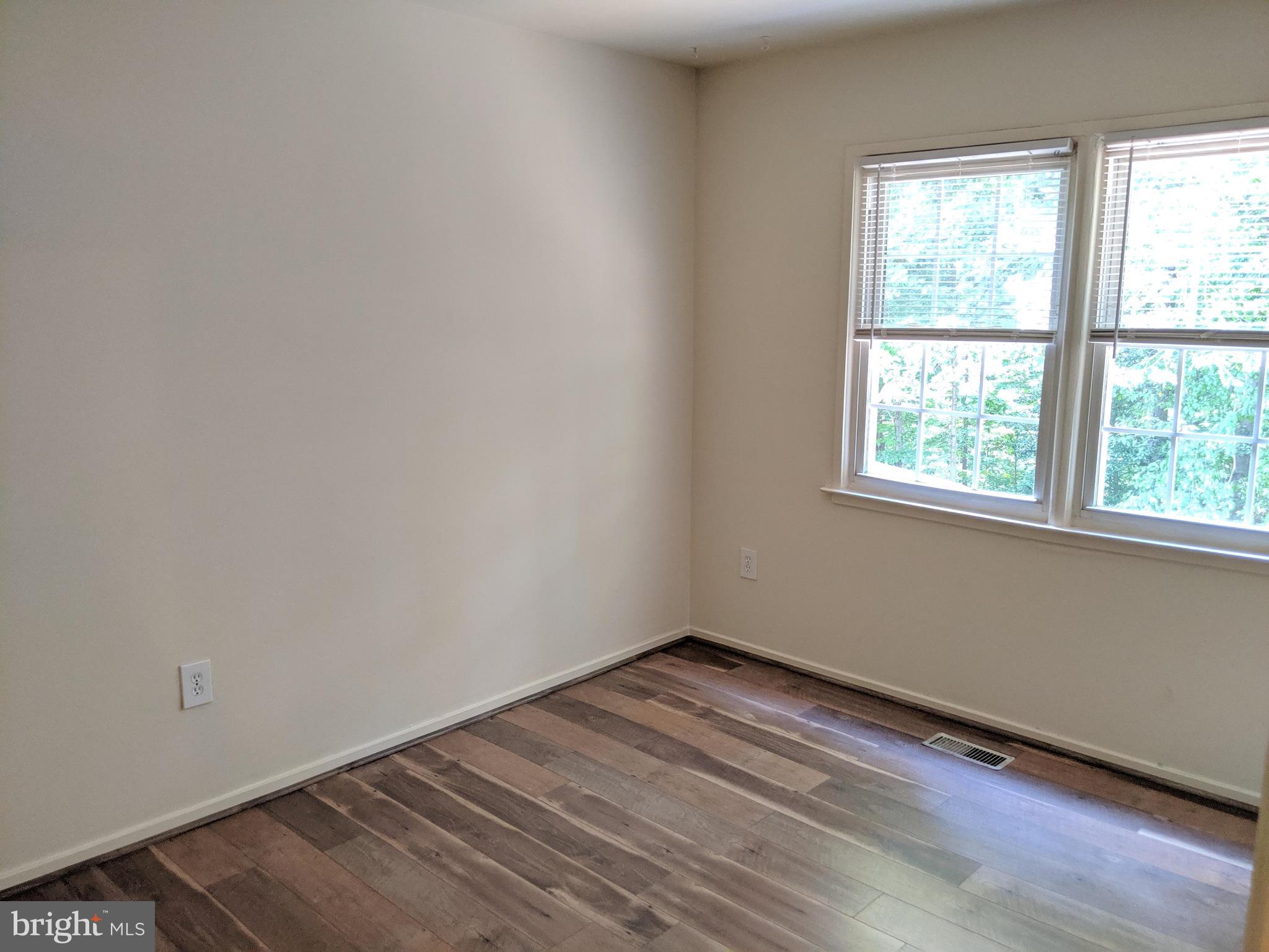 7760 Matisse Way Springfield, VA 22153 - Photo 16 of 21 an empty room with wooden floor and windows