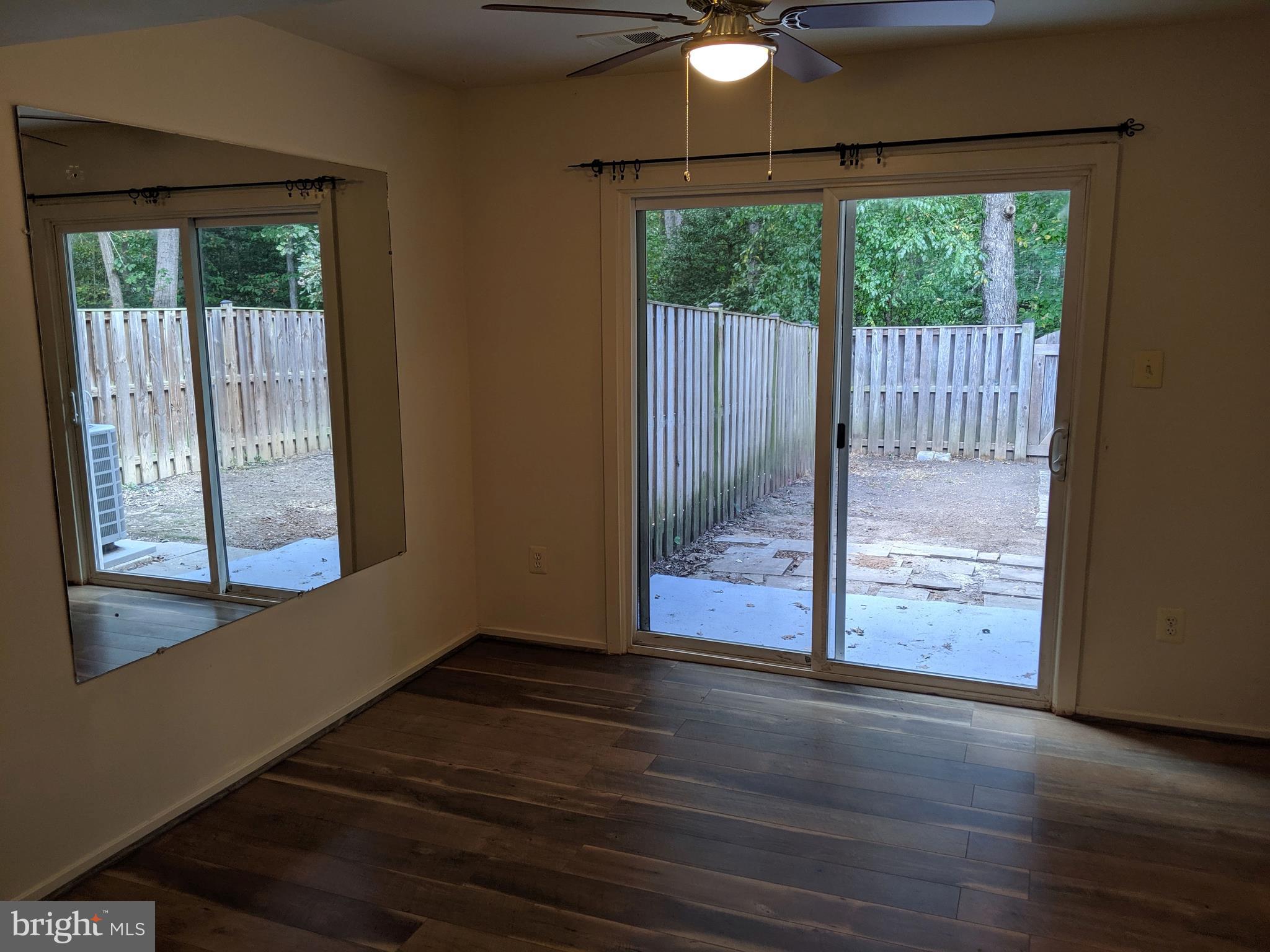 7760 Matisse Way Springfield, VA 22153 - Photo 5 of 21 a view of a livingroom with wooden floor a ceiling fan and a window
