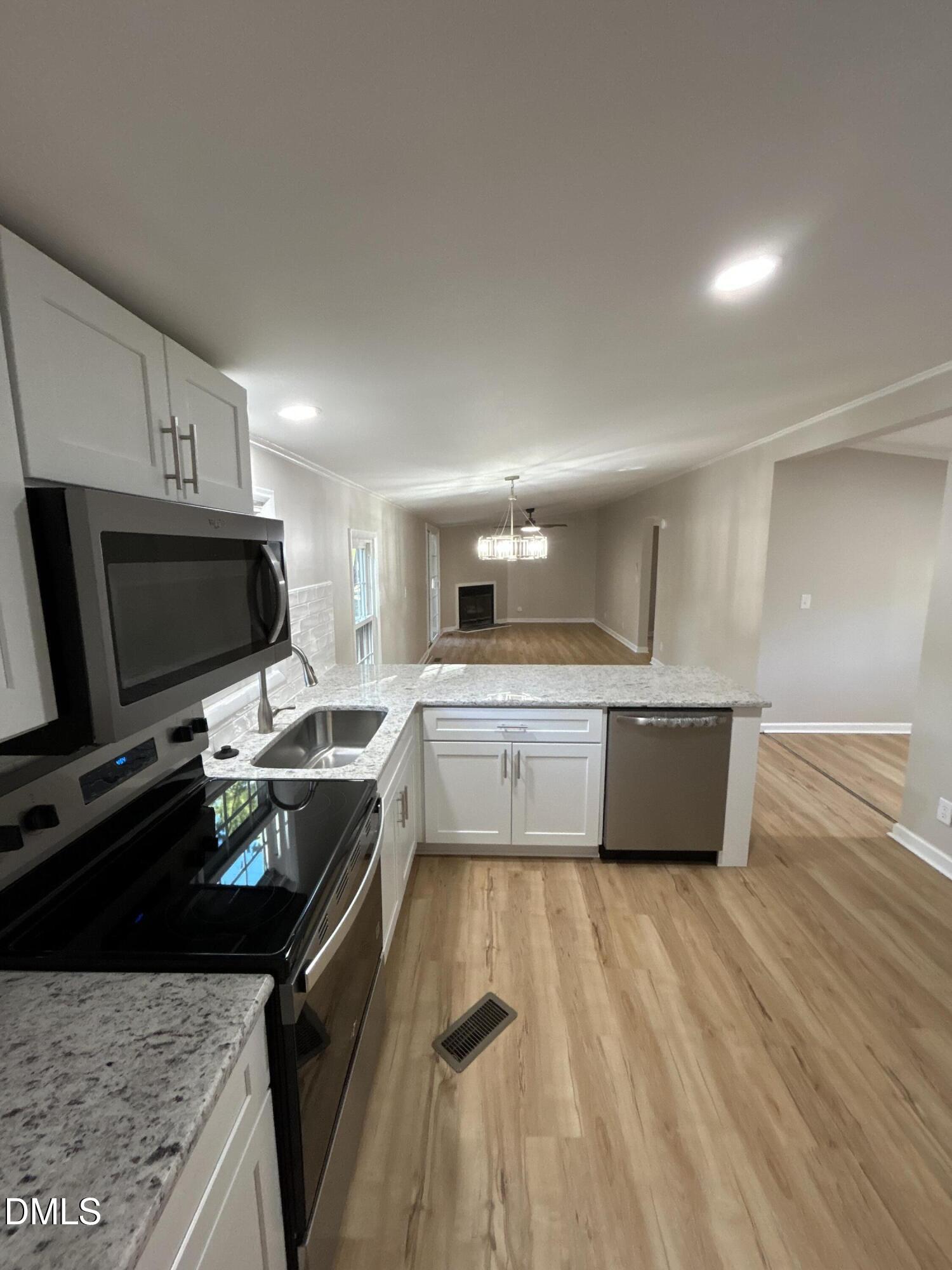 223 7th Street Wake Forest, NC 27587 - Photo 2 of 9 a kitchen with a stove a sink and a refrigerator