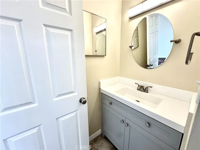 a bathroom with a sink vanity and a mirror