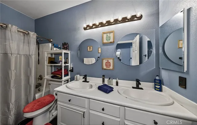 a bathroom with a sink vanity mirror and toilet