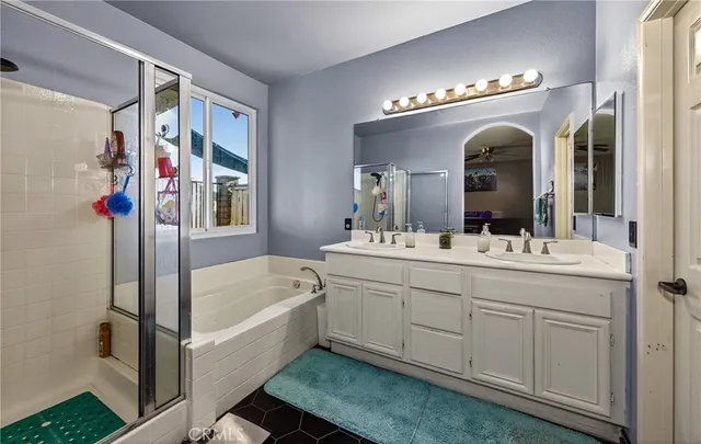 a bathroom with a double vanity sink mirror and bathtub