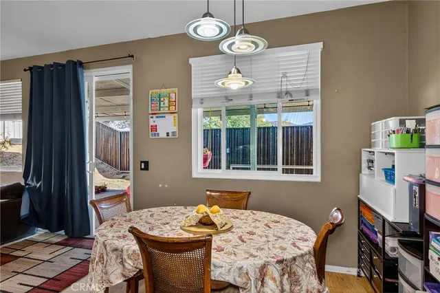 a dining room with wooden floor a chandelier a wooden table and chairs
