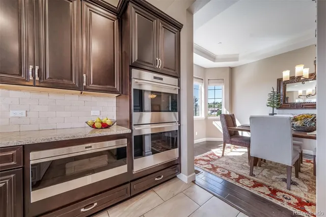 a kitchen with granite countertop wooden cabinets and stainless steel appliances