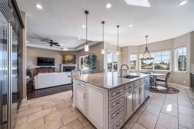 a kitchen with stainless steel appliances kitchen island granite countertop a sink and a wooden floors