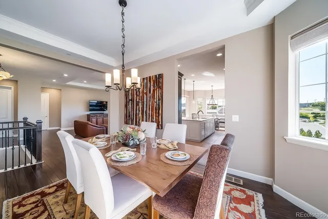 a dining room with furniture a chandelier and window