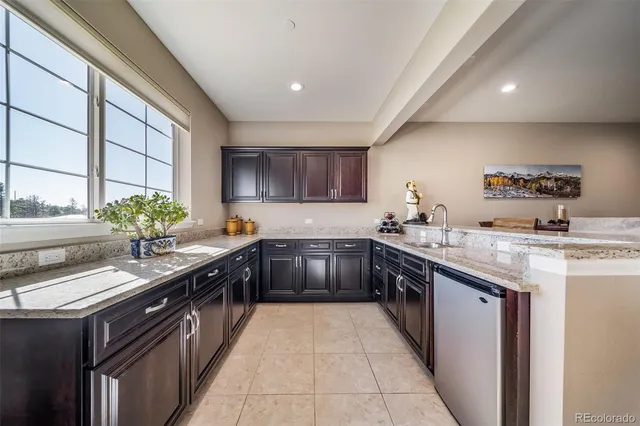 a large kitchen with stainless steel appliances granite countertop a sink counter space and a large window