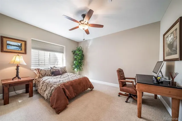 a bedroom with a bed a desk chair and a window