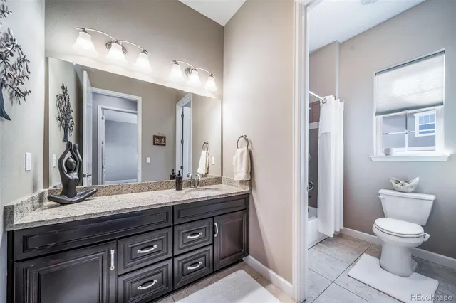 a bathroom with a granite countertop toilet sink and a mirror