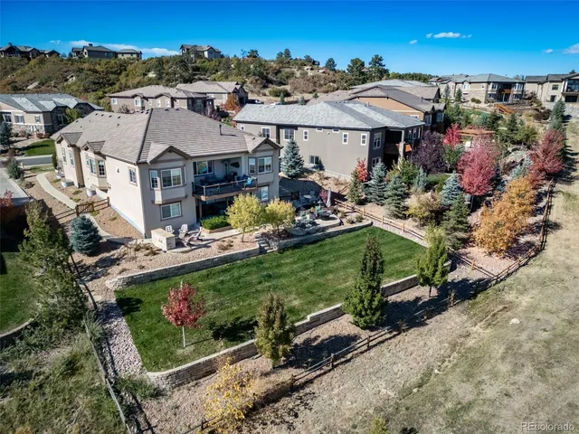 an aerial view of a house with a garden and outdoor seating