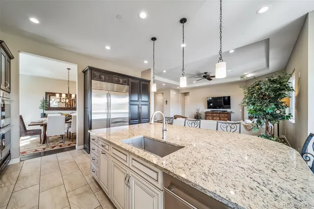 a kitchen with a sink a counter top space appliances and a chandelier