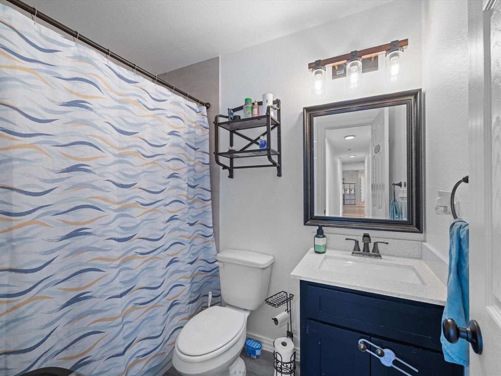 781 Alsdorf Road Ennis, TX 75119 - Photo 13 of 39 a bathroom with a granite countertop sink mirror vanity and toilet