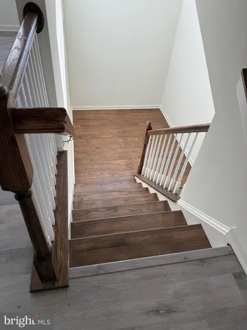 a view of staircase with wooden floor and black wall