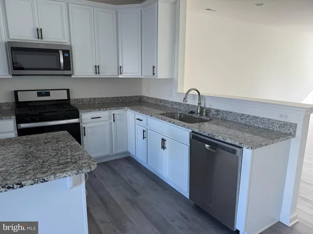 a kitchen with sink cabinets and stainless steel appliances