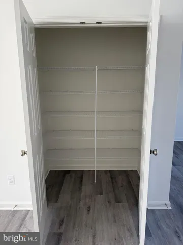 a view of walk in closet with wooden floor