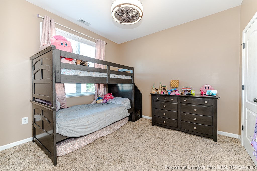 463 Juno Drive Broadway, NC 27505 - Photo 22 of 30 a bedroom with a bed and a chandelier