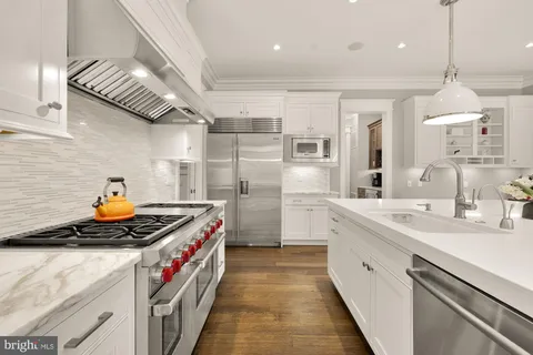 a kitchen with stainless steel appliances granite countertop a sink stove and cabinets