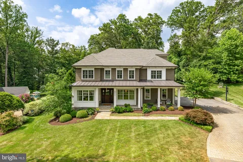 a front view of a house with swimming pool and green space