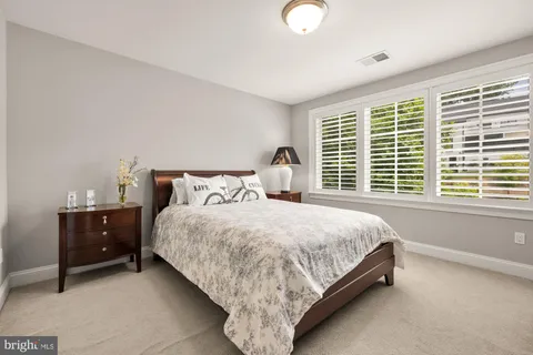 a bedroom with a bed and a painting on the wall