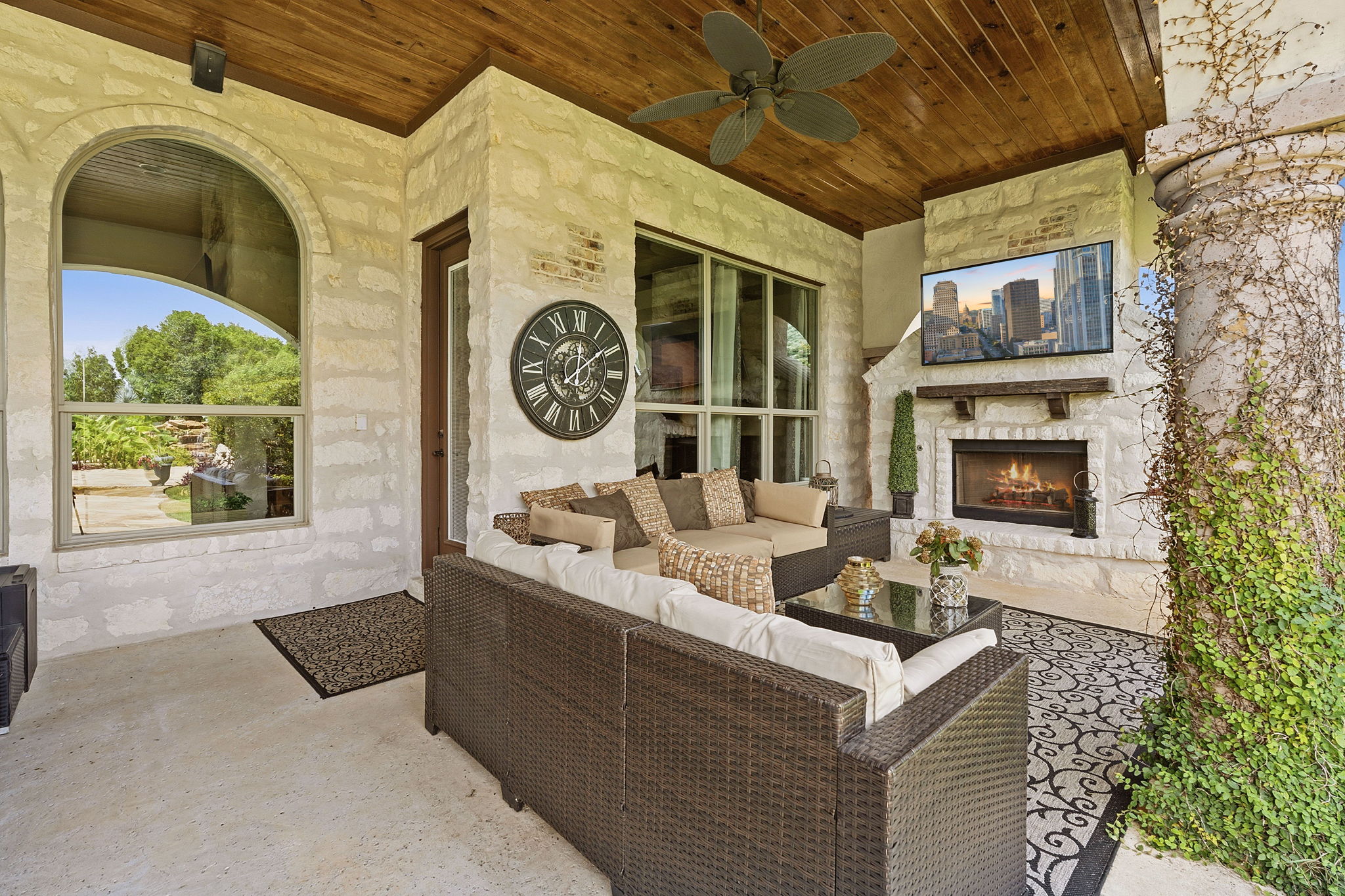 816 Brave Face Street Leander, TX 78641 - Photo 28 of 40 An inviting covered patio featuring a stone fireplace and comfortable outdoor seating for serene evenings.
