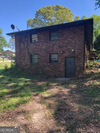 a view of a brick house next to a yard
