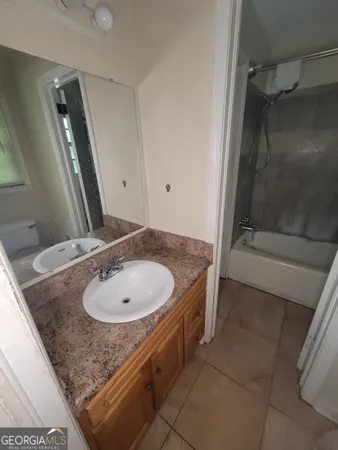 a bathroom with a granite countertop sink and mirror