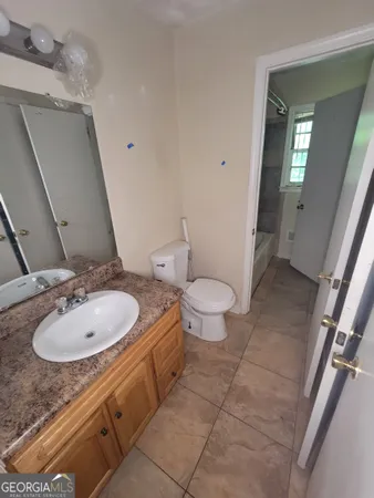 a bathroom with a granite countertop sink a toilet and a mirror