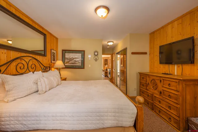 a bedroom with a bed and a flat screen tv