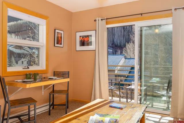 a living room with furniture a flat screen tv and floor to ceiling window