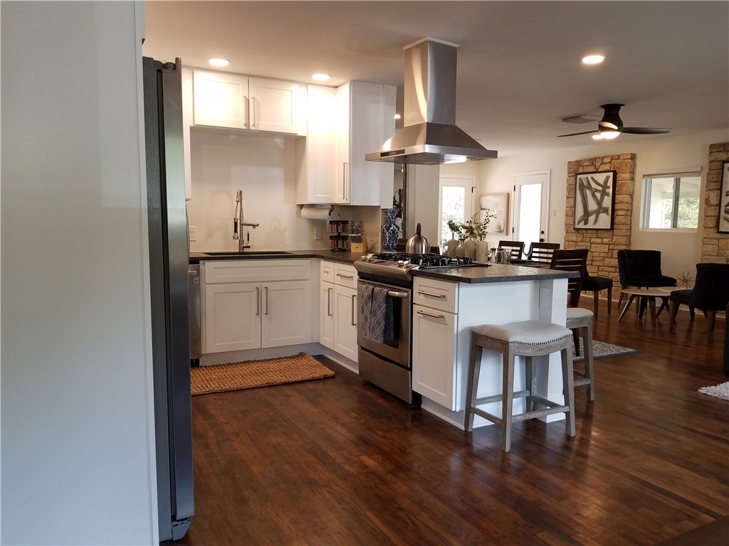 5405 Hudson Street Austin, TX 78721 - Photo 10 of 37 An inviting open-concept kitchen features dark hardwood flooring and sleek stainless steel appliances.