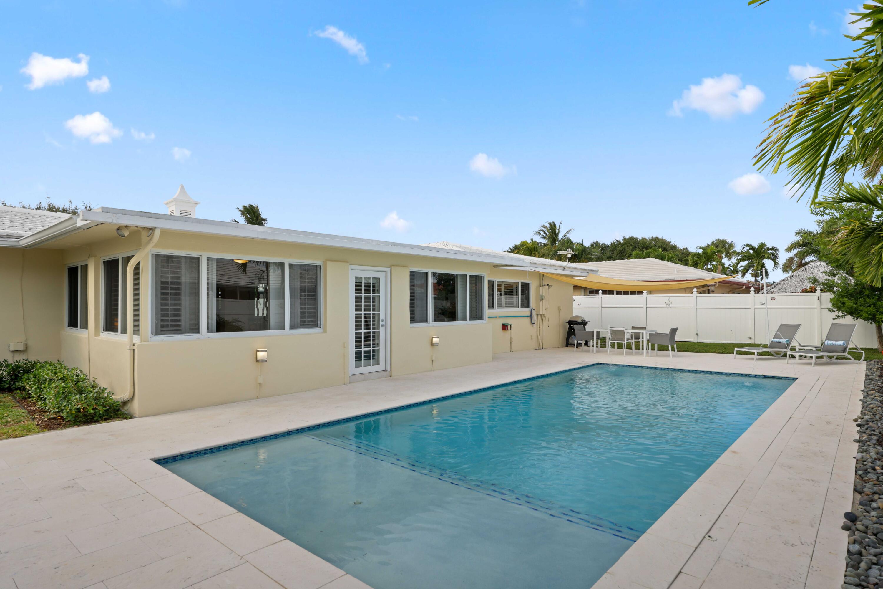 4220 Northeast 26th Terrace Lighthouse Point, FL 33064 - Photo 24 of 30 a front view of a house with swimming pool and a yard