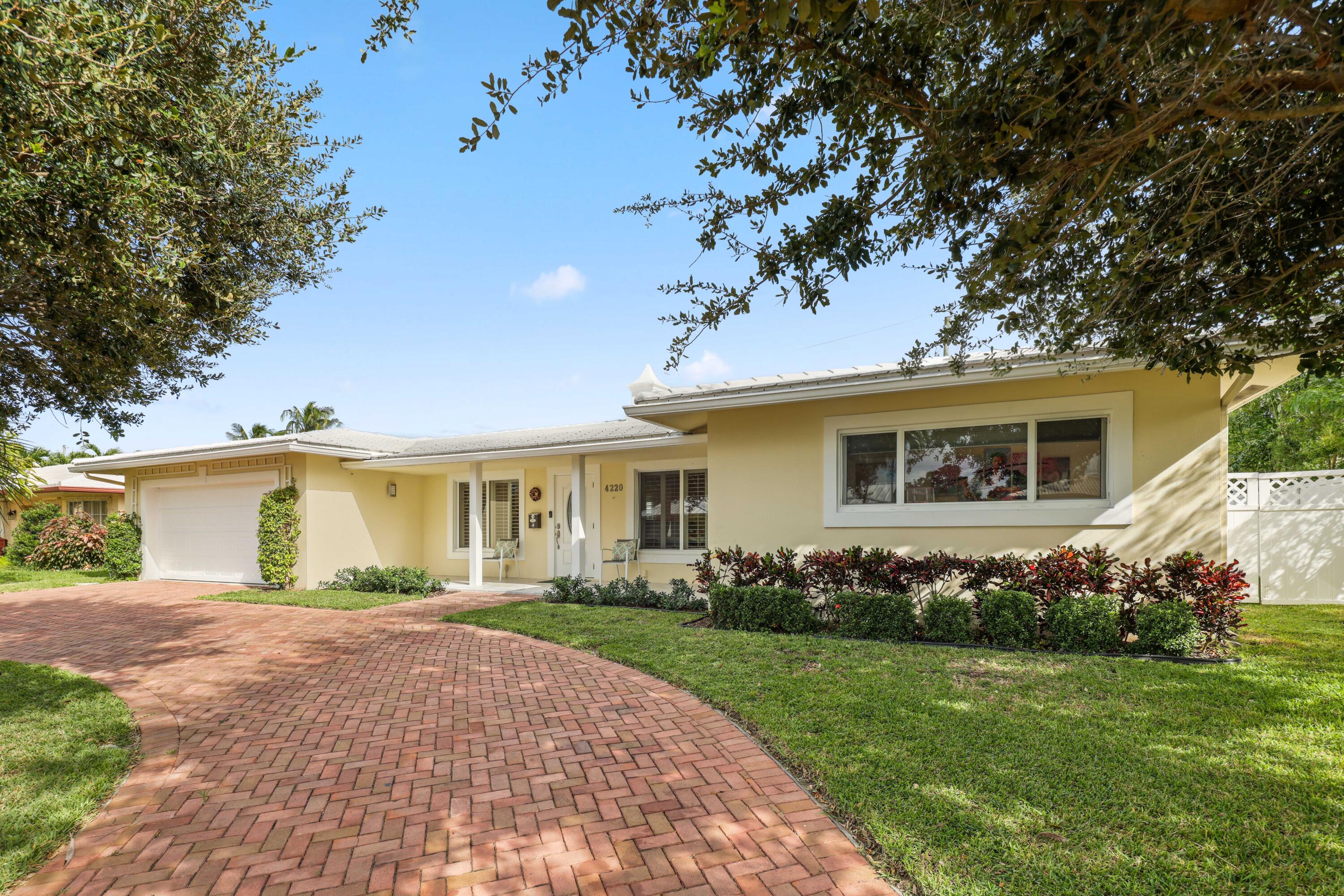 4220 Northeast 26th Terrace Lighthouse Point, FL 33064 - Photo 4 of 30 a front view of a house with a garden